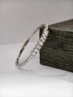 Silver stone kada bracelet featuring a row of large oval white stones flanked by smaller round stones.