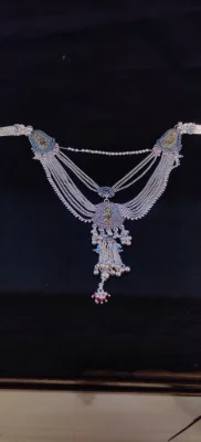 Oxidised silver half waist chain featuring multiple layered strands, hanging bells, and engraved floral motifs with blue stones.