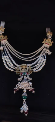 This multi layer silver waist chain features traditional temple motifs, beaded strands, and hanging charms with red and green stones.