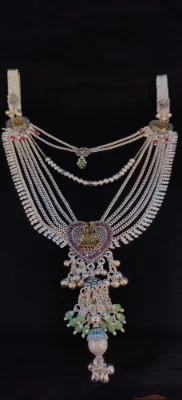 Silver layered half waist chain featuring multiple delicate chains, a central heart motif pendant with deities, and dangling ghungroos.