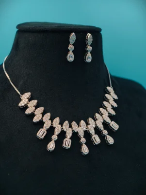 Silver stone necklace set featuring sparkling white stones in marquise and baguette shapes with matching drop earrings.