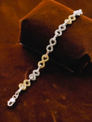 A silver Italian bracelet featuring interlocking infinity shaped links with textured pattern and dual tone polish.