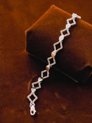 A silver Italian bracelet featuring alternating diamond-shaped open links and smooth leaf-shaped stations.