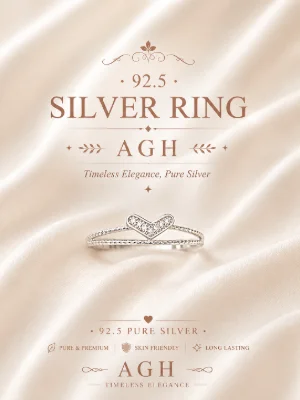 Silver ring featuring a split band with a heart shaped centerpiece studded with small white stones.