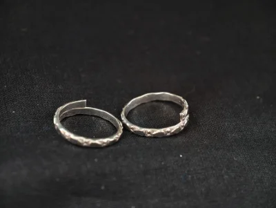 Simple silver bichiya pair with patterned design and glossy finish.