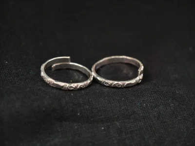 These simple silver toe rings feature a delicate embossed pattern across the band.