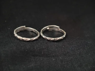 Simple silver bichiya pair with textured pattern and open ends for daily wear.