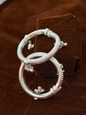 Silver kada pair featuring textured rope patterns and dangling ghungroos.