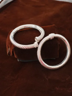 Silver children kada pair with textured pattern and shiny finish.