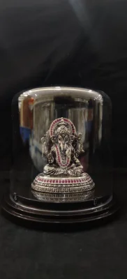 Oxidised silver ganesha idol featuring intricate carvings and red stone embellishments on a decorated base.