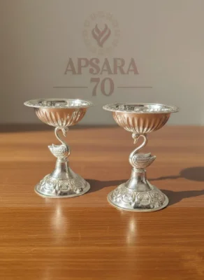 Glossy silver decorative lamp featuring a swan stem and round patterned base.