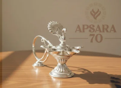 Glossy silver decorative lamp featuring multiple wicks and an ornate peacock top.