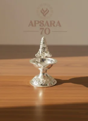 This decorative silver oil lamp features an intricate traditional pattern and a shiny polished finish.