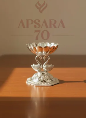 This glossy silver decorative oil lamp features a lotus bowl supported by two intertwined swans on a hexagonal base.