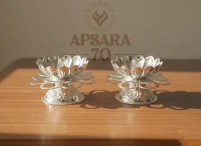 This pair of decorative silver lamps features a lotus petal design with an intricate circular base.