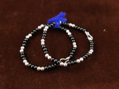 A pair of silver kadli bracelets featuring alternating black and metallic silver beads with a simple hook clasp.