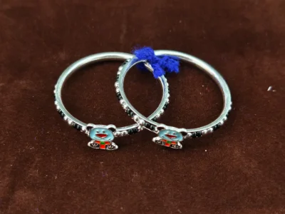 Silver kada pair featuring a cute blue enamel teddy bear motif and shiny bead pattern.