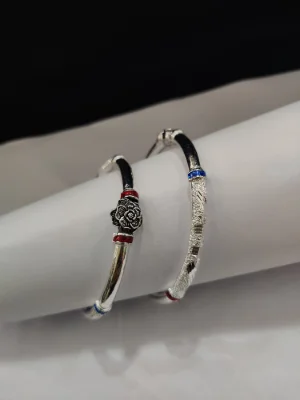 Silver ethnic bangles featuring floral motifs, textured patterns, and colorful enamel details.