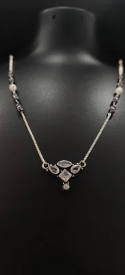 Oxidised silver mangalsutra featuring a geometric pendant with white stones and black beaded chain.