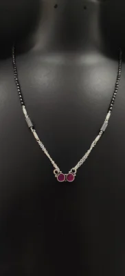 Oxidised silver mangalsutra featuring a double chain and two circular red stones in a simple locket design.