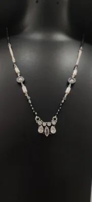 Oxidised silver mangalsutra featuring a black bead chain with silver motifs and a sparkling stone pendant.
