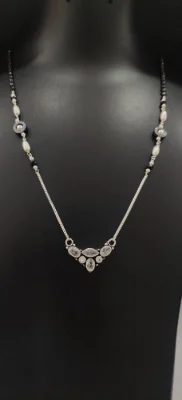 Oxidised silver mangalsutra featuring black beads, white stones, and a central pendant.