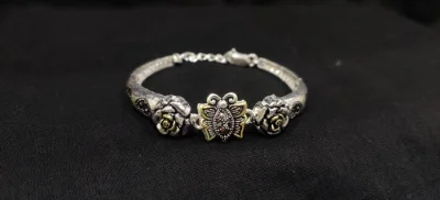 Silver oxidised bracelet featuring a central butterfly motif flanked by detailed rose designs and an adjustable chain.