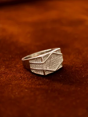 Silver ring for men featuring geometric patterns encrusted with small white stones.
