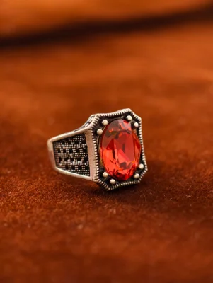 Oxidised silver male ring featuring a large oval red stone with textured patterns on the sides.