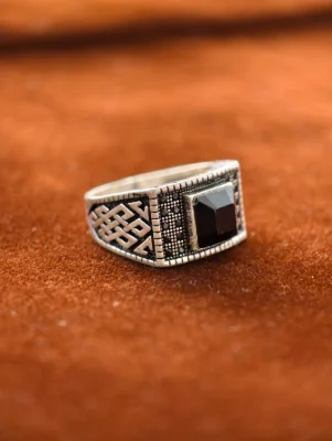 This silver men's ring features a square black stone set amidst a geometric pattern with an oxidised finish.