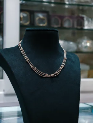 A delicate triple layer silver chain featuring small evenly spaced beads along the delicate strands.