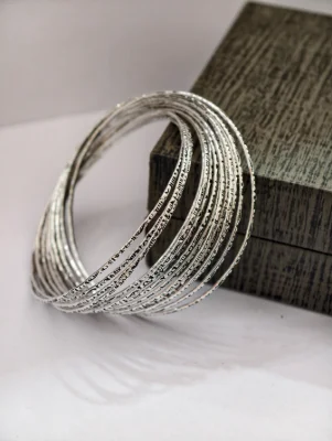 Oxidised silver designer bangles featuring intricate patterned carvings in a classic stacked round design.