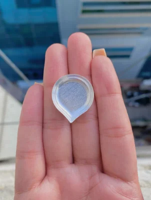 This plain silver yantra features a teardrop shaped base with a textured center and smooth raised border.