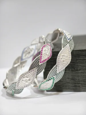 Silver bangles featuring floral motifs, textured patterns, oxidised details, and colorful stones.