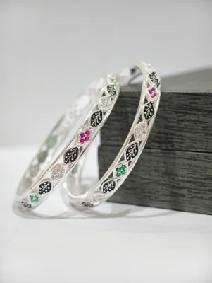 Silver bangles featuring a multicolour leaf pattern set with white, red, and green stones alongside black enamel.