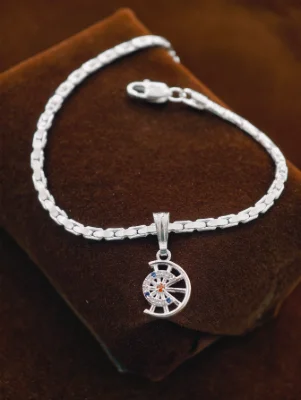 A silver chain bracelet featuring a wheel shaped pendant with white, blue and red stones.