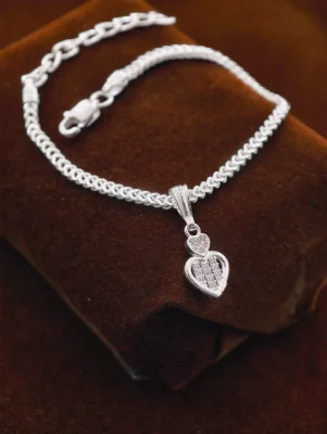 A delicate silver chain bracelet featuring a dual heart pendant adorned with small clear white stones.