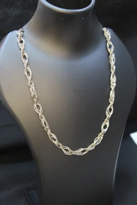 Sterling silver beaded necklace featuring a textured, intertwined design with multiple strands forming patterned loops.