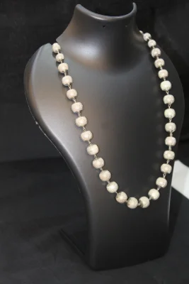 Sterling silver beaded necklace featuring textured round beads in a simple chain design.