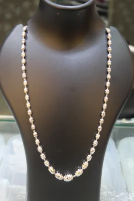 A long sterling silver beaded chain featuring shiny textured round silver beads linked together in a continuous pattern.