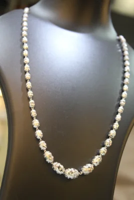 Sterling silver beaded necklace featuring shiny textured oval beads in a continuous design.