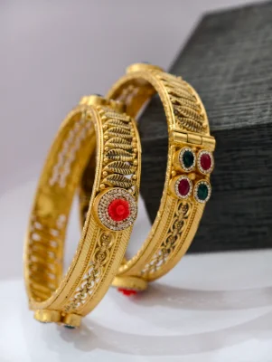 Gold polished silver kada with leaf patterns, red floral centerpiece, and multi coloured stone accents.