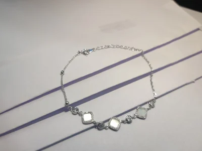Lightweight silver bracelet featuring square stations with white stones, sparkling round stones, and a delicate chain.